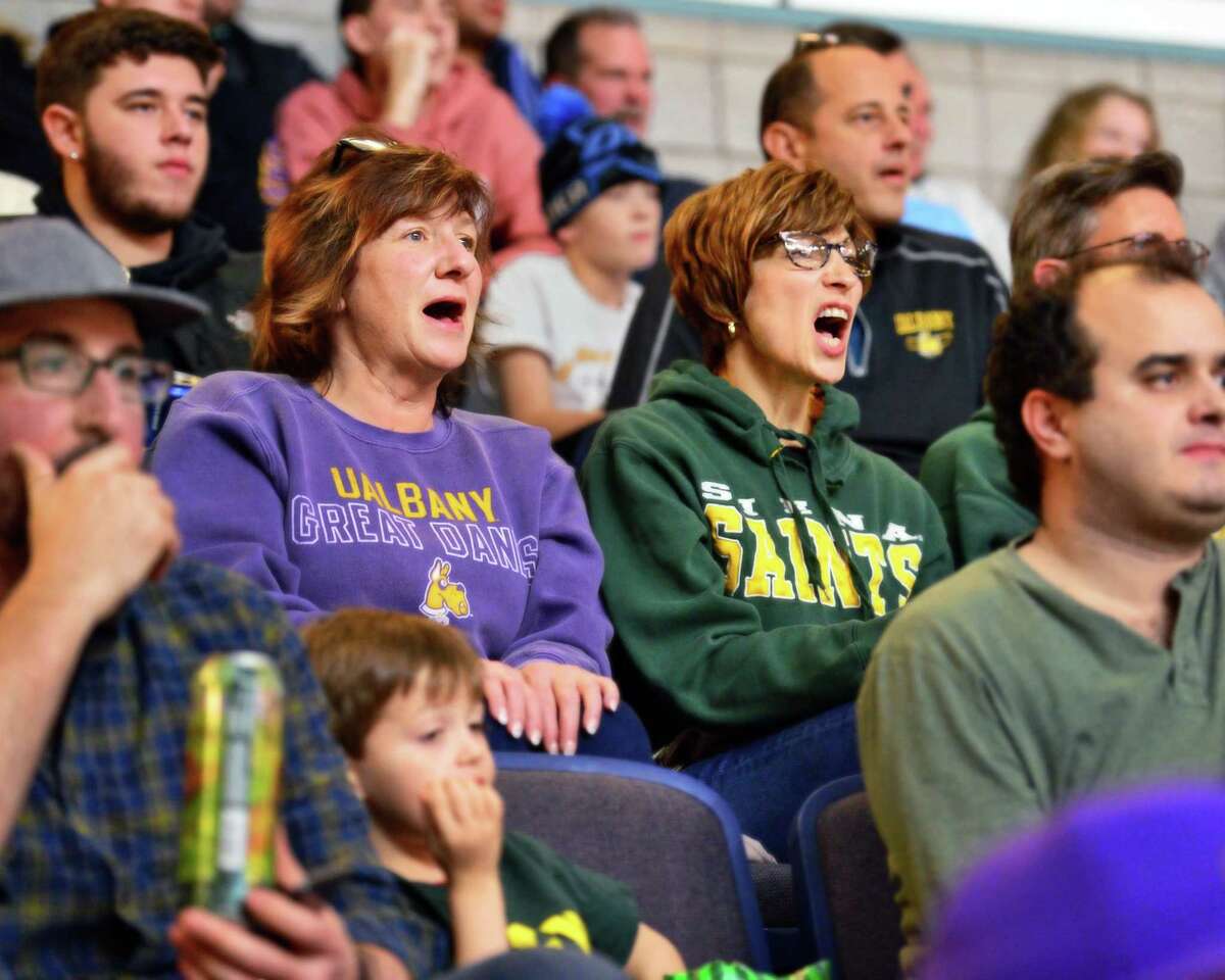 Sisters Michelle Wolsey, left, of Ballston Spa and Maria Guyette of Albany root for opposing teams during the Albany Cup game between UAlbany and Siena College Saturday Dec. 9, 2017 in Albany, NY. (John Carl D'Annibale / Times Union)