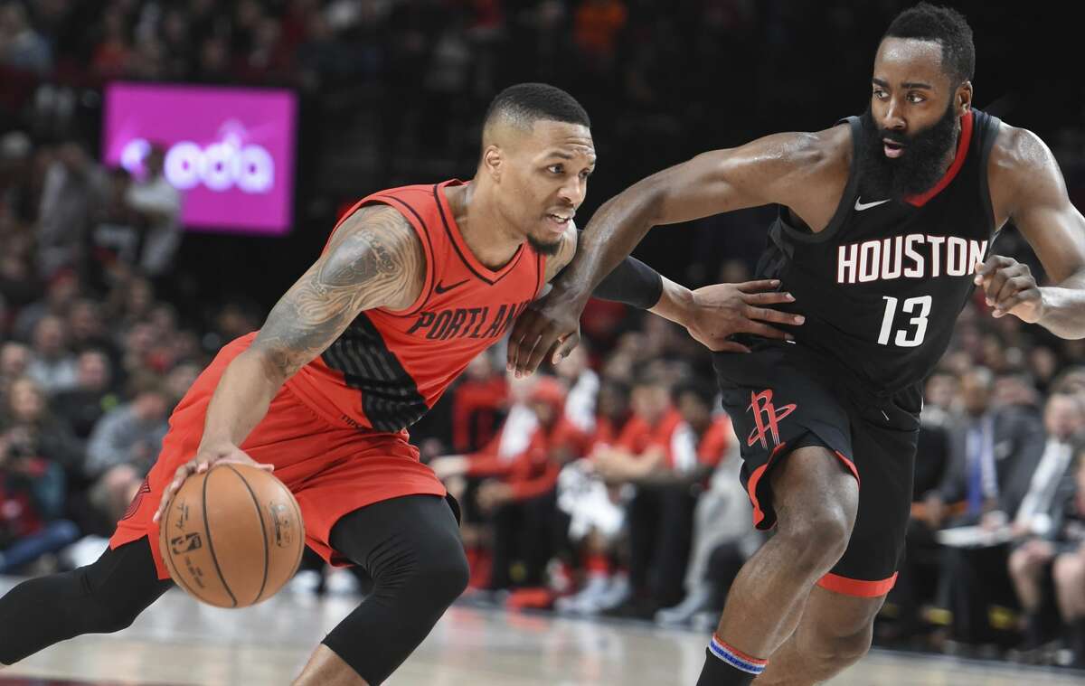Portland Trail Blazers guard Damian Lillard drives to the basket on Houston Rockets guard James Harden during the second half of an NBA basketball game in Portland, Ore., Saturday, Dec. 9, 2017. The Rockets won 124-117. (AP Photo/Steve Dykes)