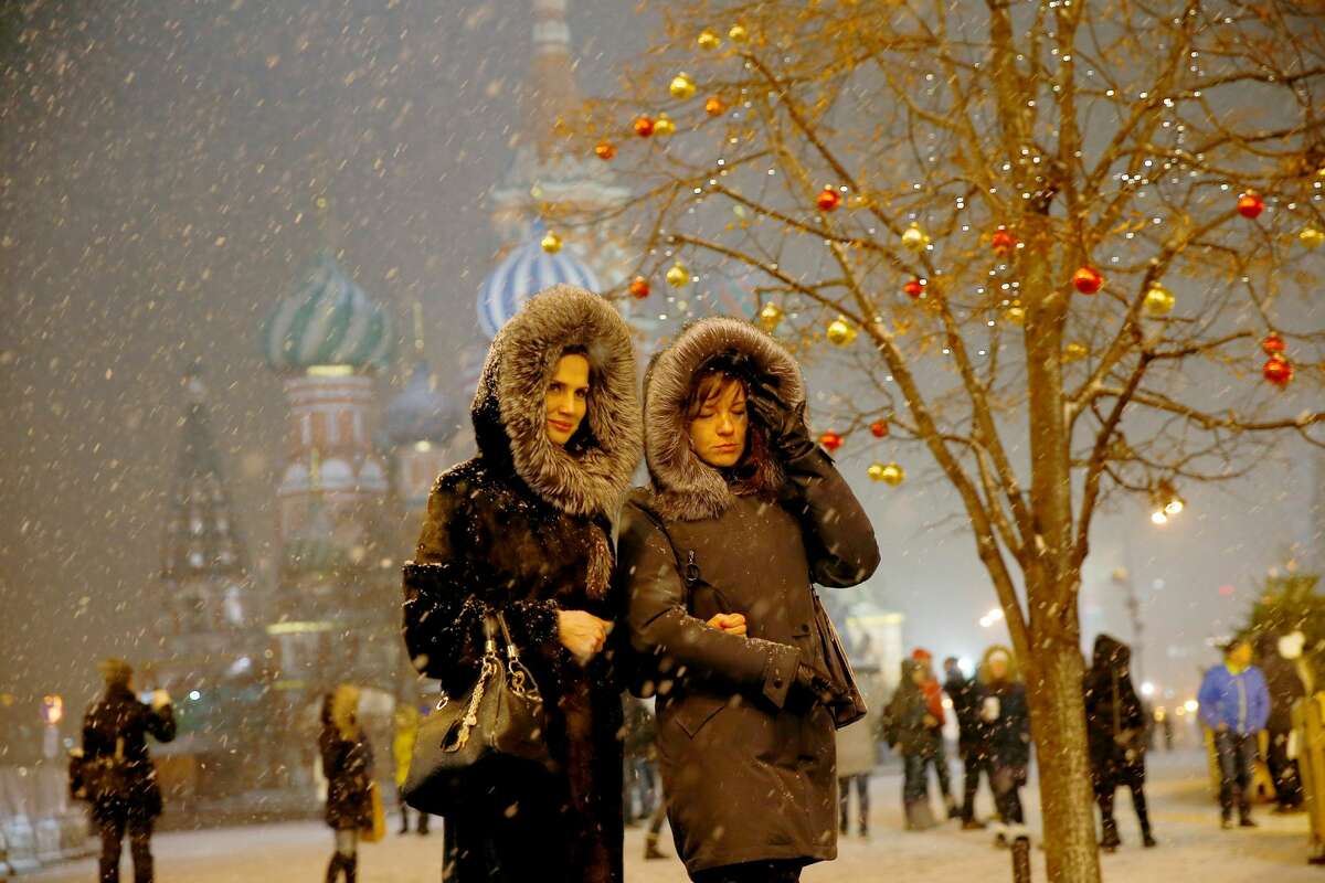People walk during snowfall at the Red Square in Moscow, Russia on December 04, 2017.