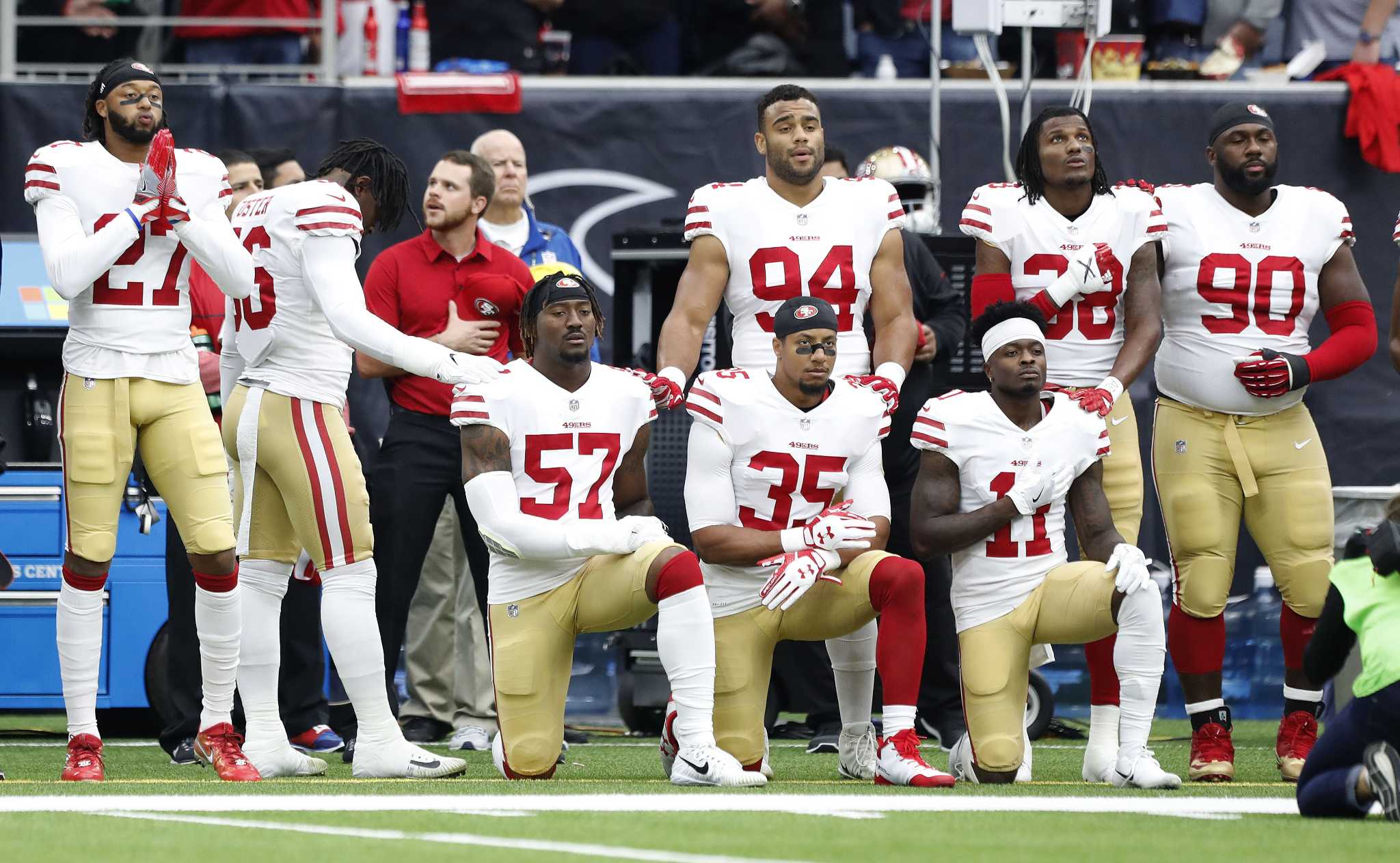 In this Dec. 10, 2017, file photo, San Francisco 49ers' Eli Harold (57),  Eric Reid (35) and Marquise Goodwin (11) kneel during the national anthem  before an NFL football game against the