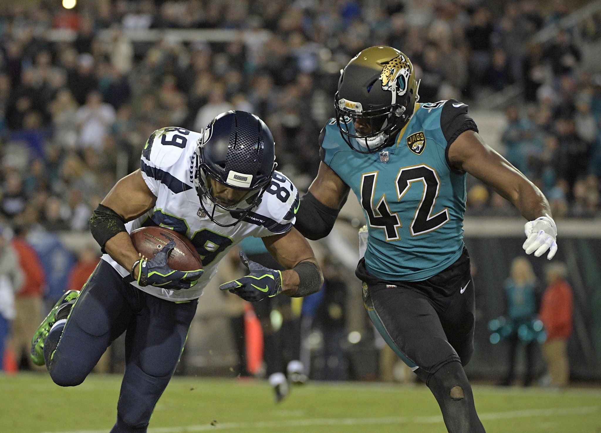 Seahawks' Quinton Jefferson tries to climb into stands to confront fans