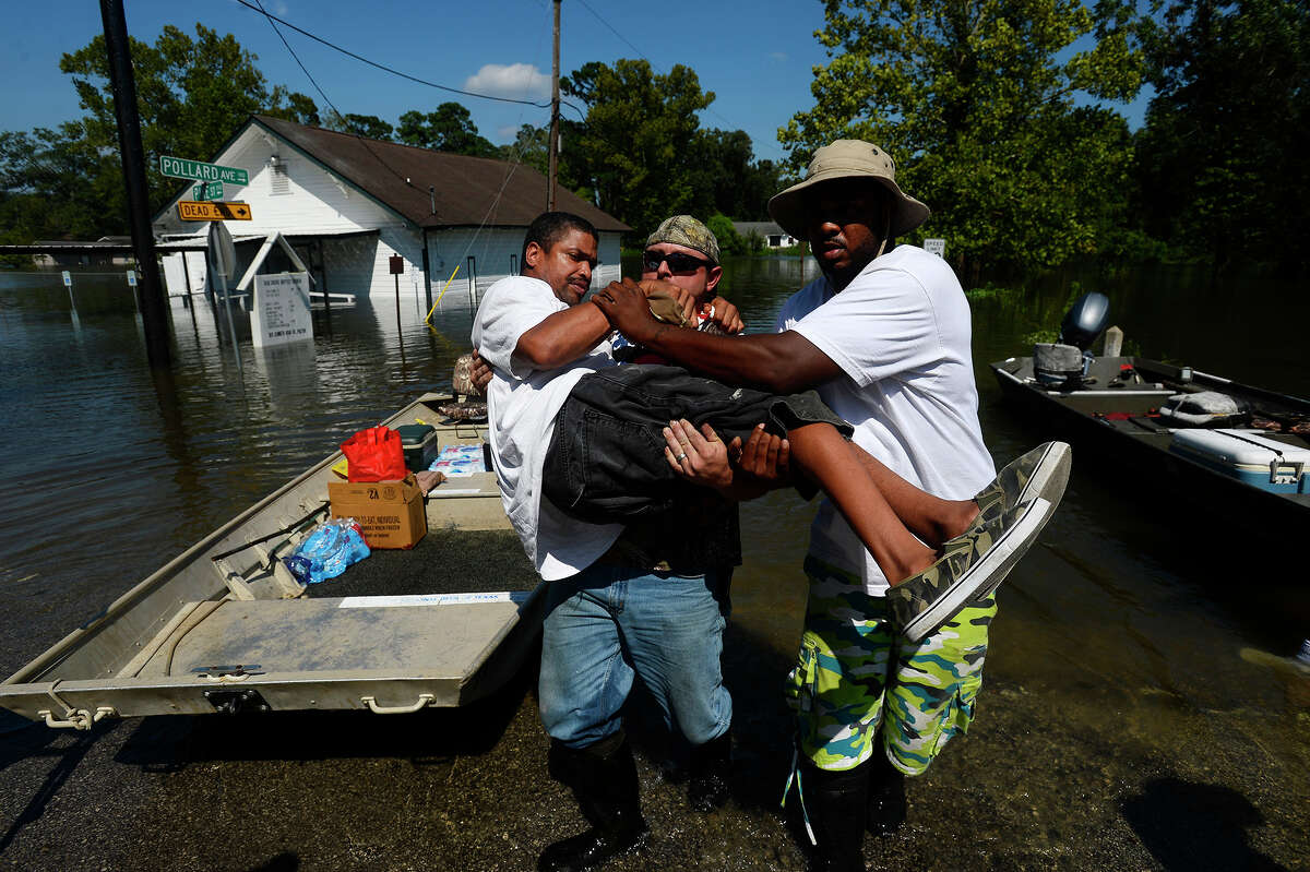 Chris McCarty and Mike Taylor help carry Quintin Sanders, who has cerebral palsy, off a rescue boat in the north end of Beaumont, Texas on Thursday, Aug. 31, 2017. McCarty came from Lufkin, Texas to help rescue people from flooding due to Tropical Storm Harvey. Photo taken Thursday 8/31/17 Ryan Pelham/The Enterprise