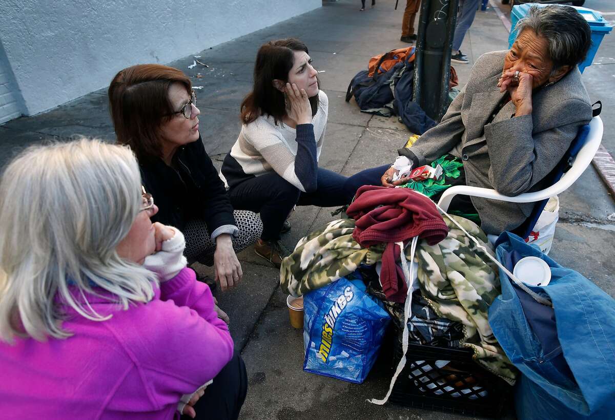 From left, Rory Ryan, Anne Gallagher and Supervisor Hillary Ronen visit with Alice, a homeless woman who spends her days and nights in front of the Burger King at 16th and Mission streets, in San Francisco, Calif. on Wednesday, Nov. 29, 2017.
