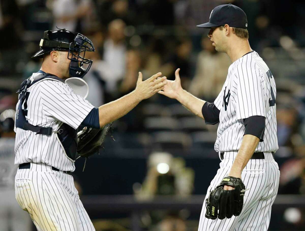 New York Yankees catcher Brian McCann, left, congratulates New York Yankees relief pitcher Chris Martin after Martin closed out the Yankees 4-2 victory over the Tampa Bay Rays in a baseball game at Yankee Stadium in New York, Tuesday, April 28, 2015. (AP Photo/Kathy Willens)