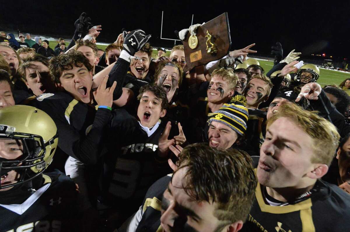 Members of the Hand football team celebrate after beating Masuk to win the Class L championship on Monday in Trumbull.