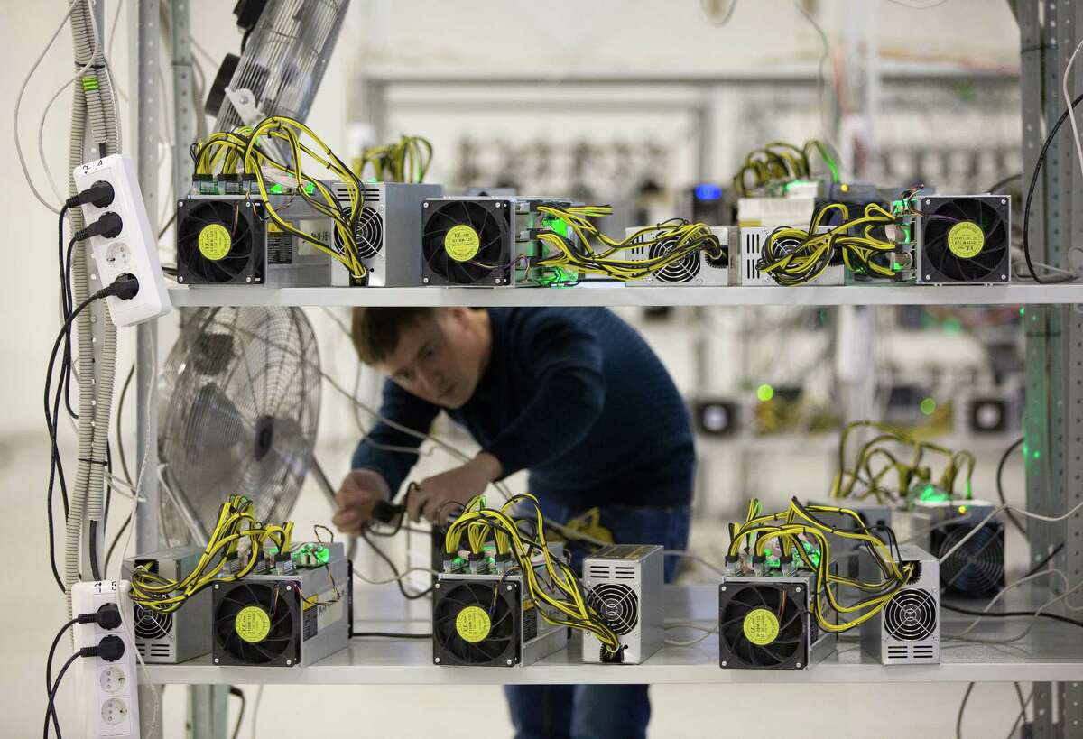 An employee checks power supply units and cooling fans used in cryptocurrency mining systems in Moscow.﻿