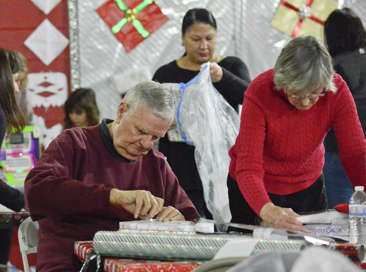 Ron Domonkos of Stamford and his wife Carmen, a member of Inspirica's Board of Directors, join a brigade of volunteers as they wrap some 6,000 personalized holiday gifts for 3,000 children in Fairfield County at Inspirica in Stamford, Conn. on Dec. 9, 2017. The recipients of the gifts are kids impacted by poverty, AIDS and homelessness.