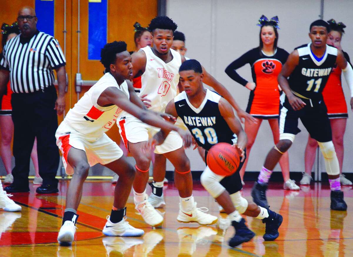 Edwardsville’s Jaylon Tuggle, left, defends with teammate R.J. Wilson, behind, providing support against Gateway on Tuesday.