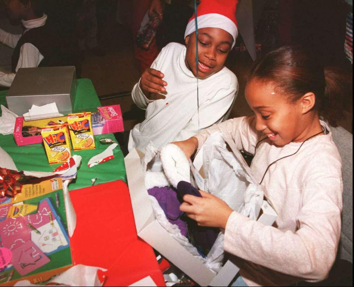 Adreana Andrews and Deanna Reason open gifts during a Christmas party at St. John's Episcopal Church on Dec. 18, 1996.