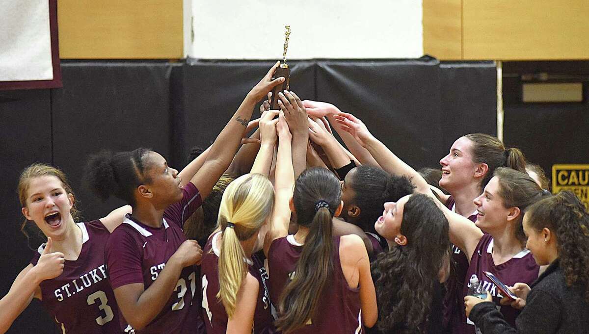 Members of the St. Luke's girls basketball team celebrate their 2017 FAA championship, which the Storm on Saturday with an 82-55 victory over Greenwich Academy at Carey Gymnasium in New Canaan.