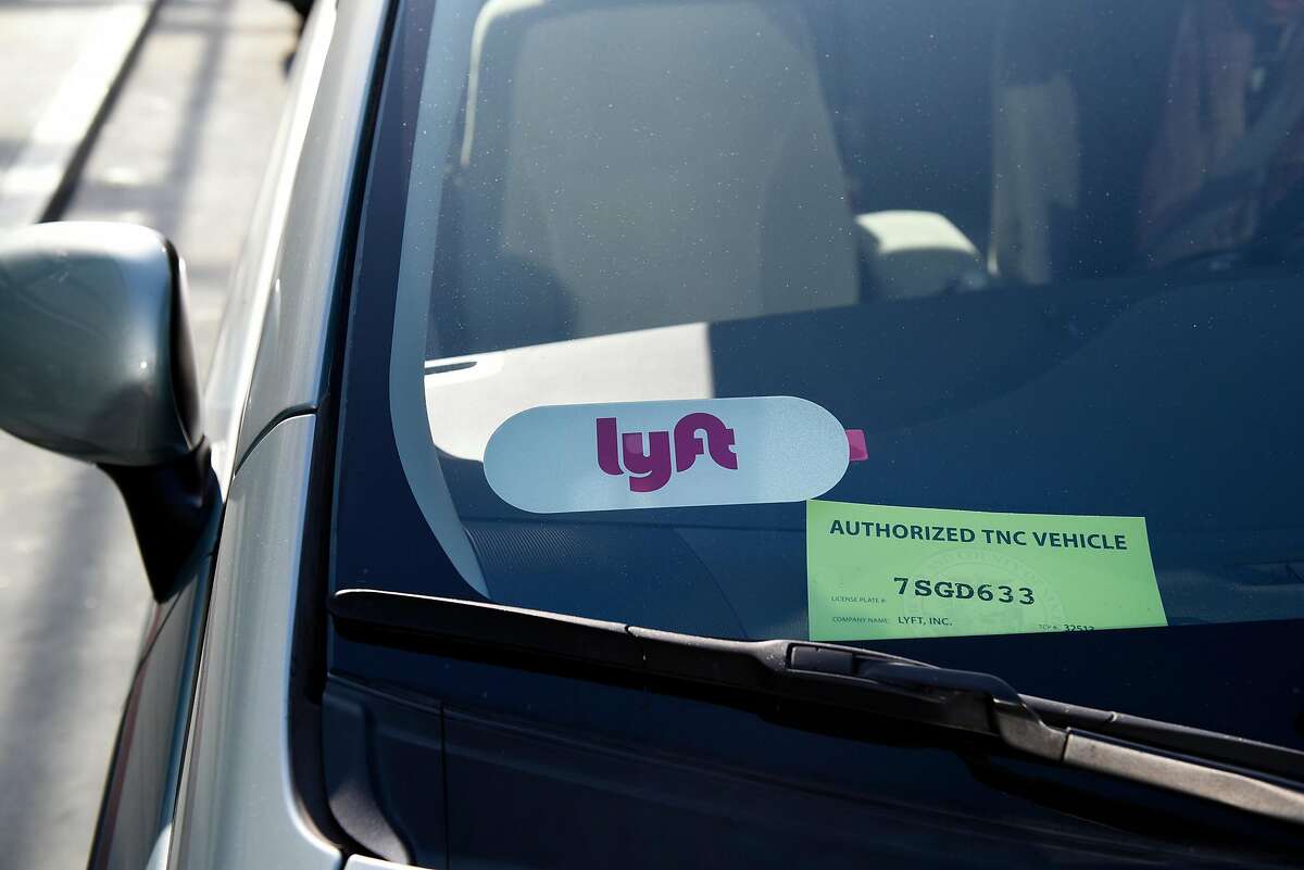 A Lyft sticker and a TNC licensing card are seen in the window of a ride share car at San Francisco International Airport in San Francisco, Calif., on Wednesday December 13, 2017.