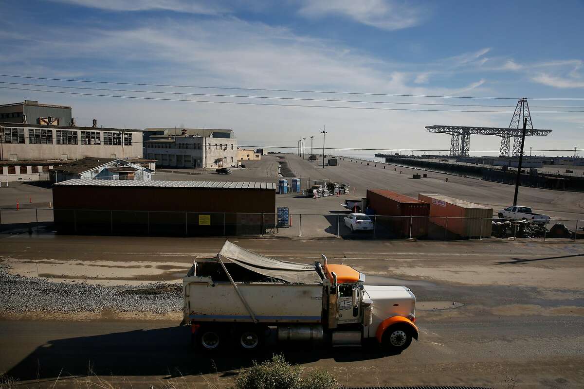 A truck passes on a road near a giant crane and buildings at Hunters Point Naval Shipyard on Monday, December 11, 2017 in Oakland, Calif.