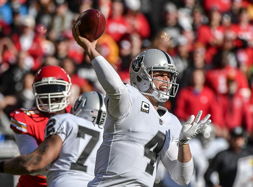 Oakland Raiders quarterback Derek Carr (4) has works with referee Carl  Cheffers (51) and umpire Bill Schuster (129) during the second half of an  NFL football game against the Kansas City Chiefs