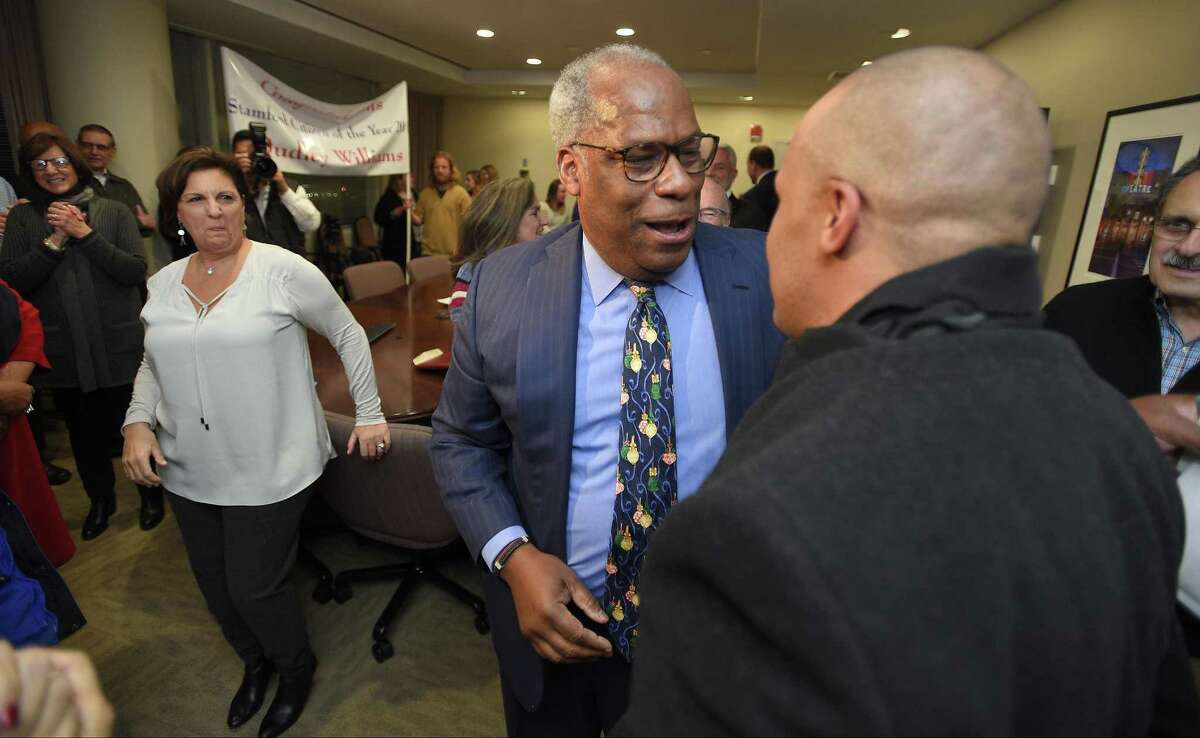 Dudley Williams, Mill River Collaborative director, center, is surprised to see his son, Dudley Williams III, of Somerville, Mass., after being named as Stamford's 2017 Citizen of the Year.