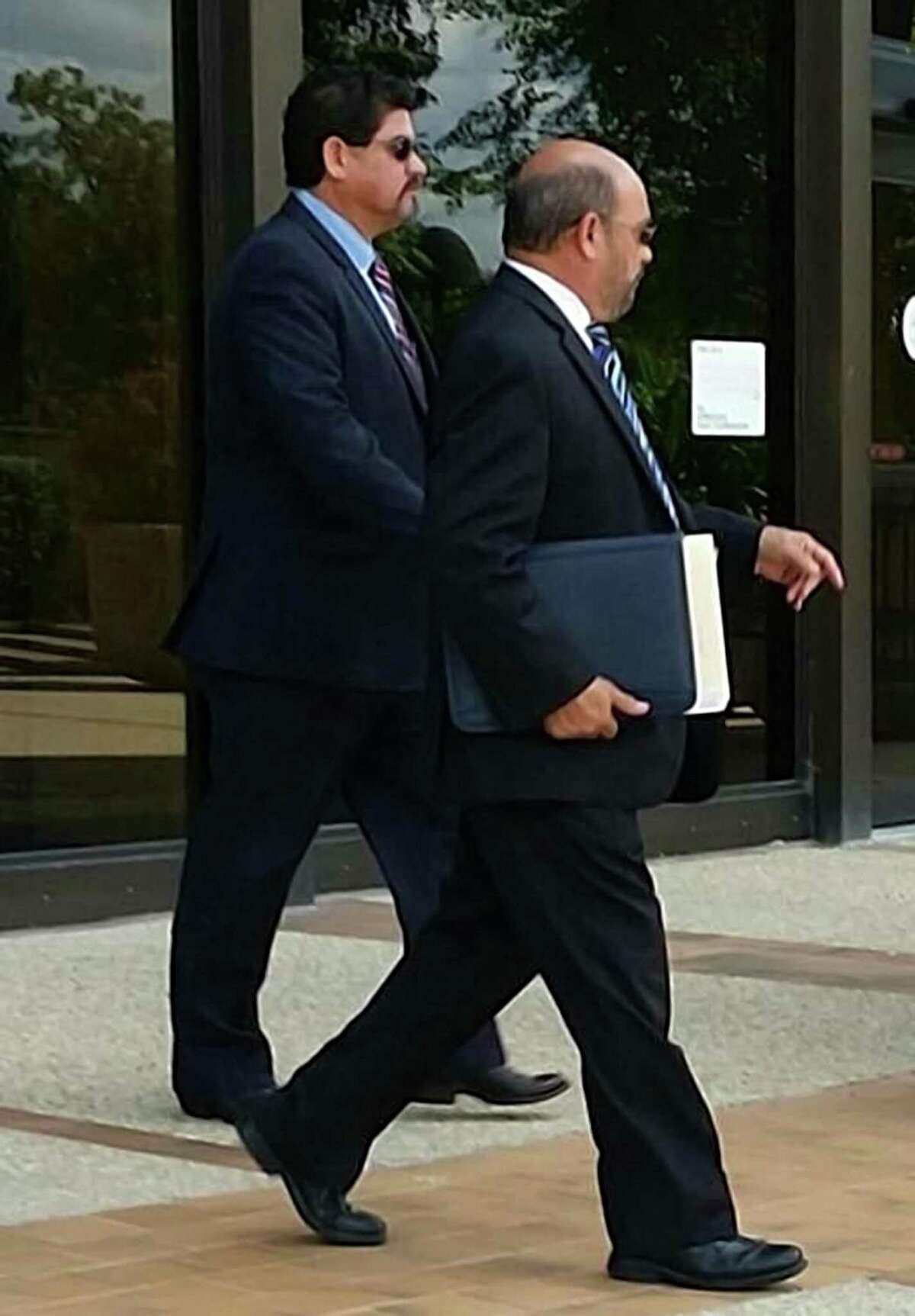 Samuel Mullen, (left) who is alleged to have bribed an insurance consultant for area school districts, walking out of federal court today in San Antonio with his lawyer, David R. Gorena (right). Mullen entered a not guilty plea to a charge of conspiracy to commit wire fraud.