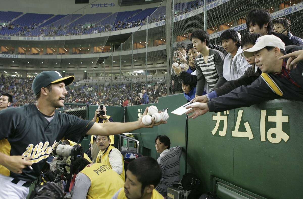 Oakland Athletics pitcher Huston Street reaches out to give fans balls signed with his autographs prior to their exhibition baseball game against Japan's Yomiuri Giants at Tokyo Dome in Tokyo, Saturday, March 22, 2008. (AP Photo/Koji Sasahara)