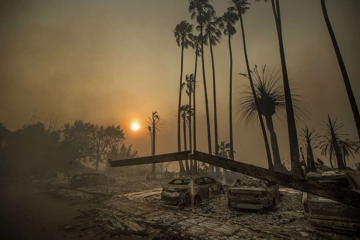 Smoke rises behind a leveled apartment complex as a wildfire burns in Ventura, Calif., on Tuesday, Dec. 5, 2017. Over 100 structures have burned so far in Ventura County, officials said. (AP Photo/Noah Berger)