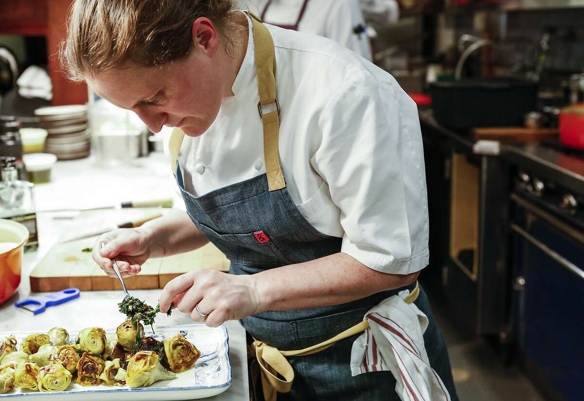 Chef April Bloomfield, chef/owner of Tosca Cafe, plates Pot-Roasted Artichokes, a recipe from her book, "A Girl and Her Greens," on Thursday, May 7, 2015 in San Francisco, Calif.
