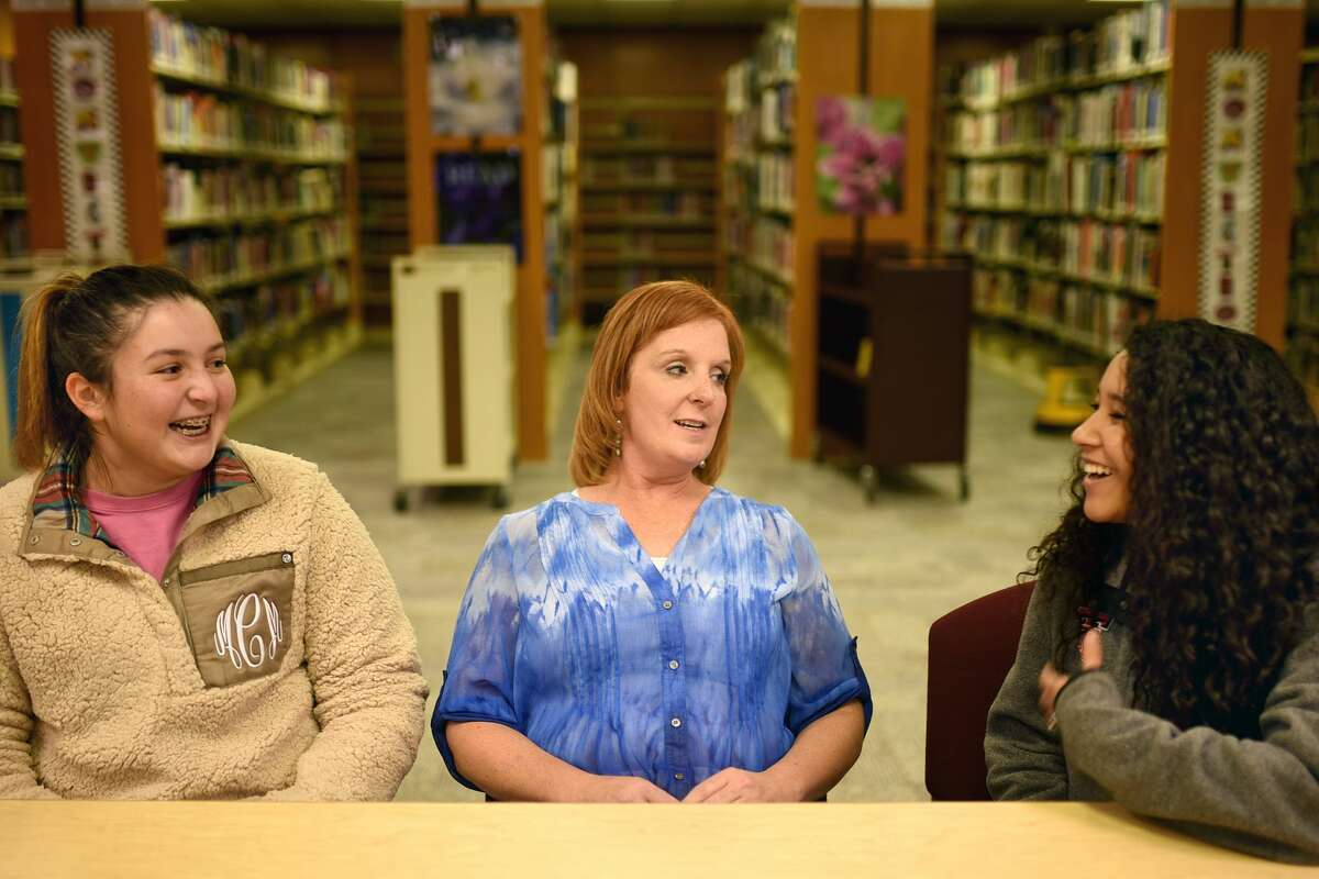 At center, Denise Vosika, an economics teacher at Lee High School, interacts with junior Madi Castro and senior Gina Khieu, Dec. 14, 2017, in the Lee High School library. James Durbin/Reporter-Telegram