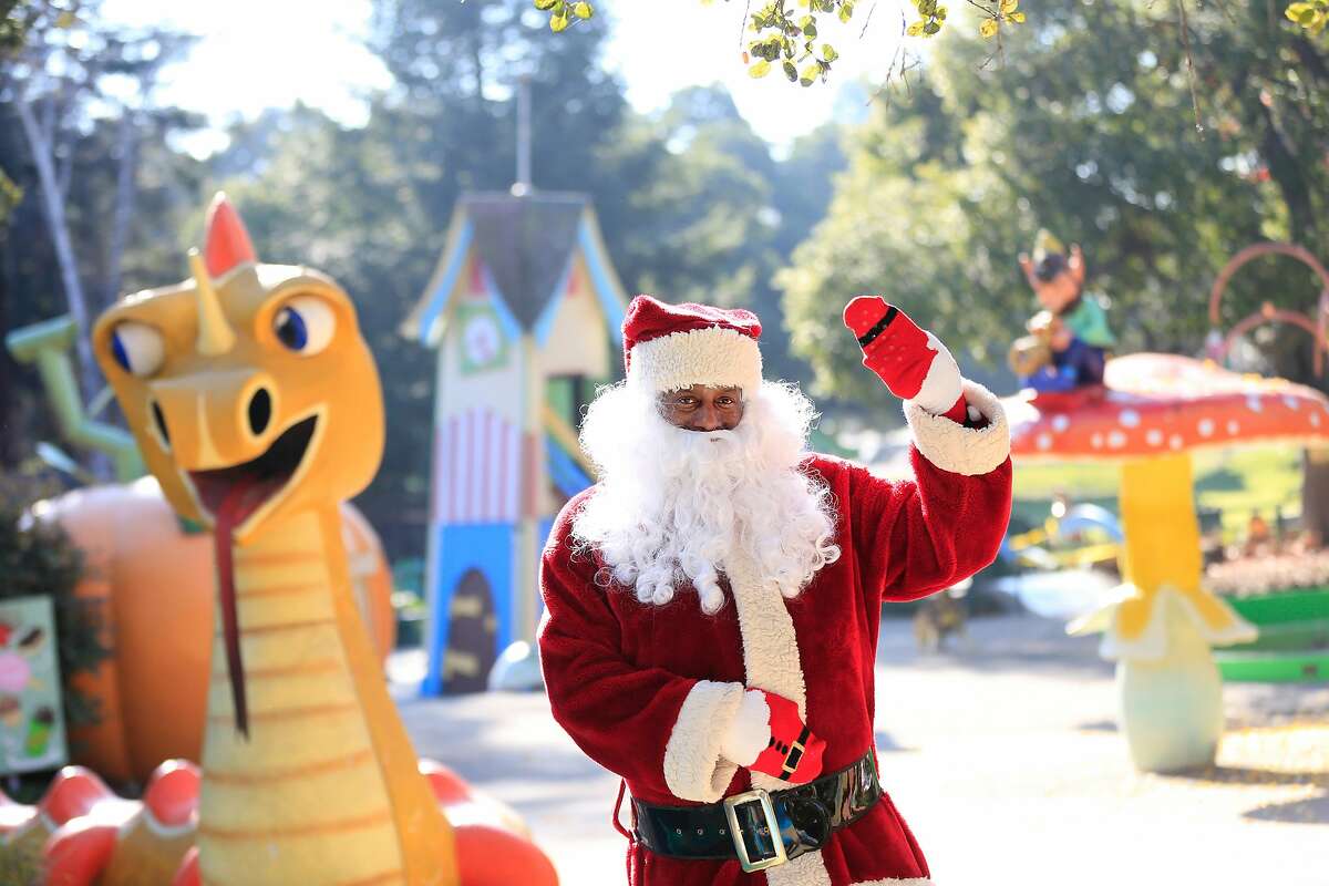 Eric Martin, Fairyland's Santa Claus, poses for a portrait next to Happy Dragon at Fairyland on Thursday, December 14, 2017 in Oakland, Calif.