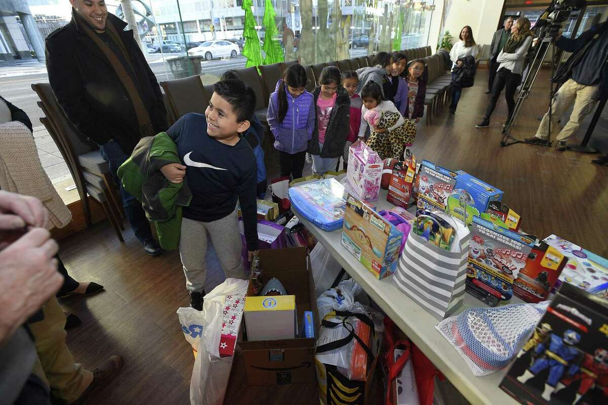 Randy Lopez Monterrozo, 8, one of nine children from the Boys and Girls Club of Stamford checks out some of the 150 toys collected by NBCUniversal employees, as part of the company's annual Holiday Toy Drive, at the Stamford Media Studio in Stamford, Conn. on Dec. 14, 2017. Employees participating in the toy drive received a personalized "wish card" from a child who participates in the clubs after school program that specified which toy he or she would like to receive. in addition to the wish card program, NBCUniversal purchased extra toys to be donated to other children at the club.