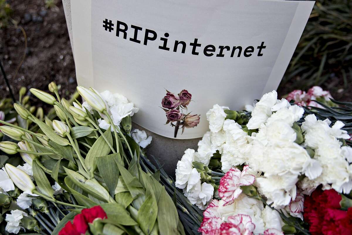 A "#RIPinternet" sign stands outside the Federal Communications Commission (FCC) headquarters ahead of a open commission meeting in Washington, D.C., U.S., on Thursday, Dec. 14, 2017. The FCC is slated to vote to roll back a 2015 utility-style classification of broadband and a raft of related net neutrality rules, including bans on broadband providers blocking and slowing lawful internet traffic on its way to consumers. Photographer: Andrew Harrer/Bloomberg