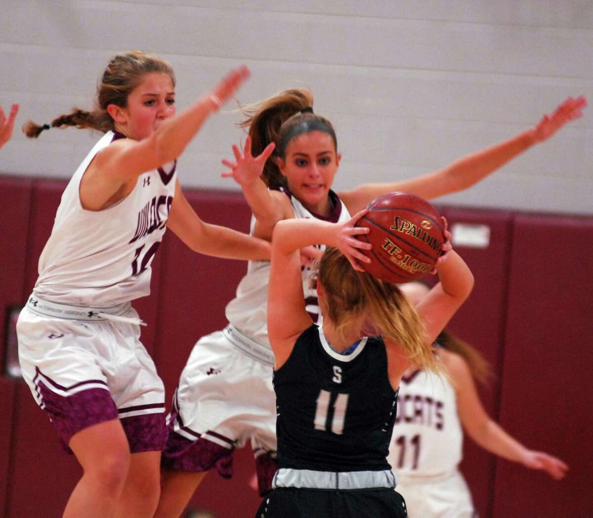 Staples’ Elle Fair is defended by Bethel’s Lily Daniels and Britney Roach during a game on Thursday.