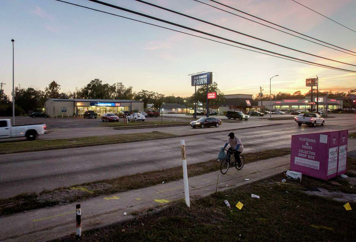 A man rides a bike past a pawn shop, located near the intersection of Homestead Road and Tidwell Road, Friday, Dec. 1, 2017, in Houston. The pawn shop was looted during Hurricane Harvey, and dozens of firearms were stolen. ( Jon Shapley / Houston Chronicle )