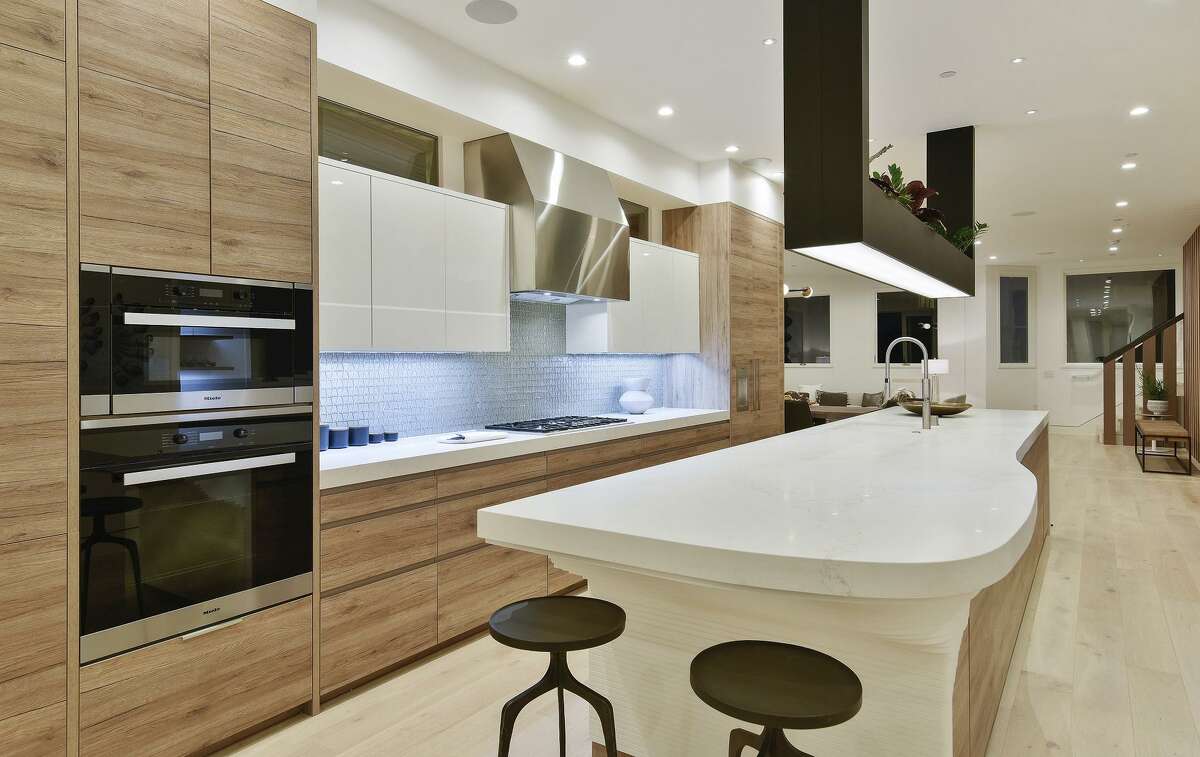 The kitchen features a 10-foot island, an integrated cooktop, and glass tile backsplash.