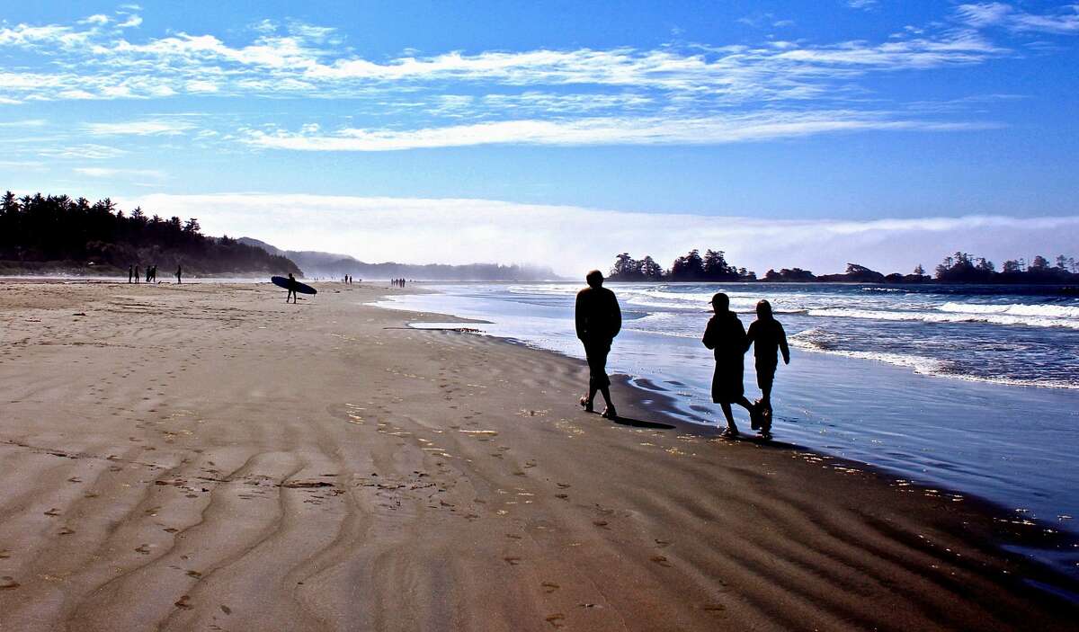 Friends walking on shore at Pacific Rim National Park, Vancouver Island, British Columbia.