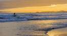 Surfer at sunset, Long Beach, Pacific Rim National Park, Vancouver Island, British Columbia.