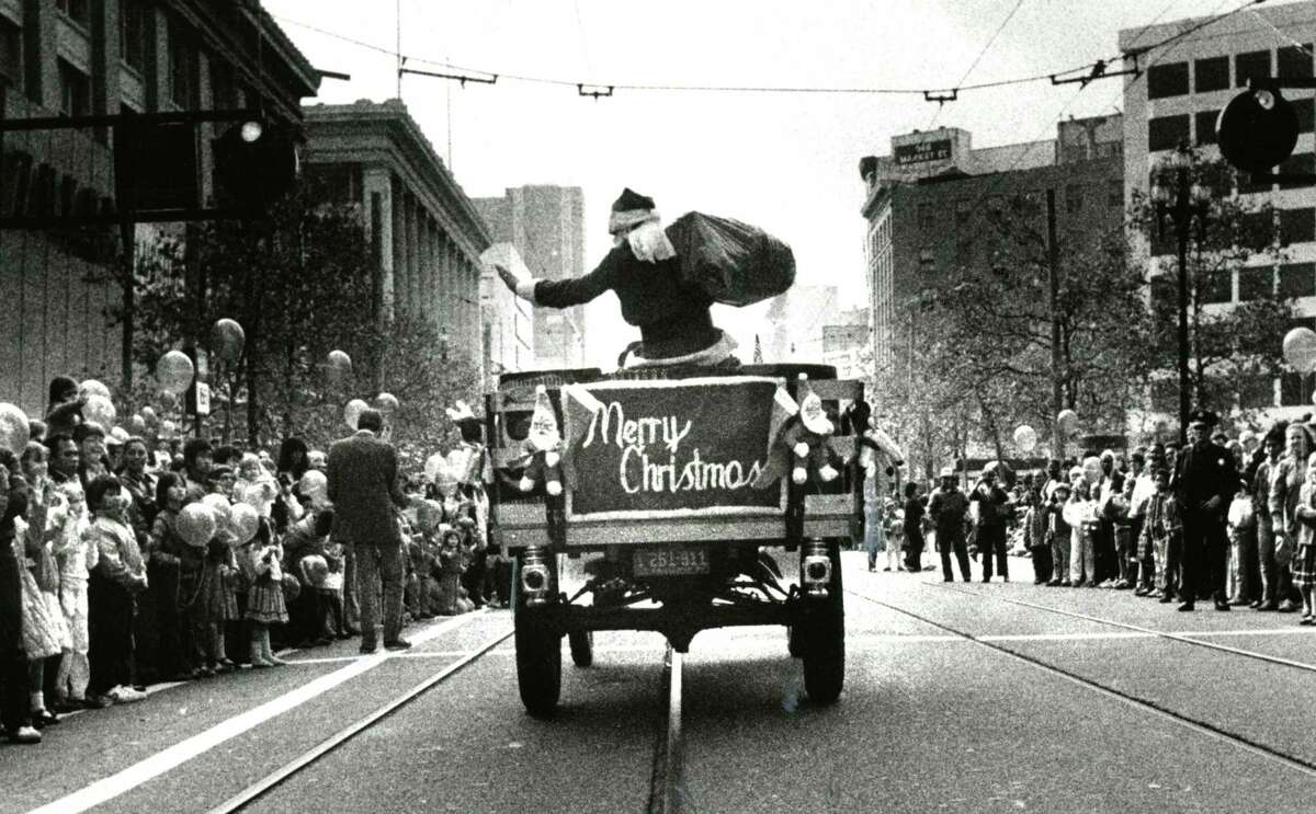 The Emporium’s Santa Claus rides down Market Street during a holiday parade.