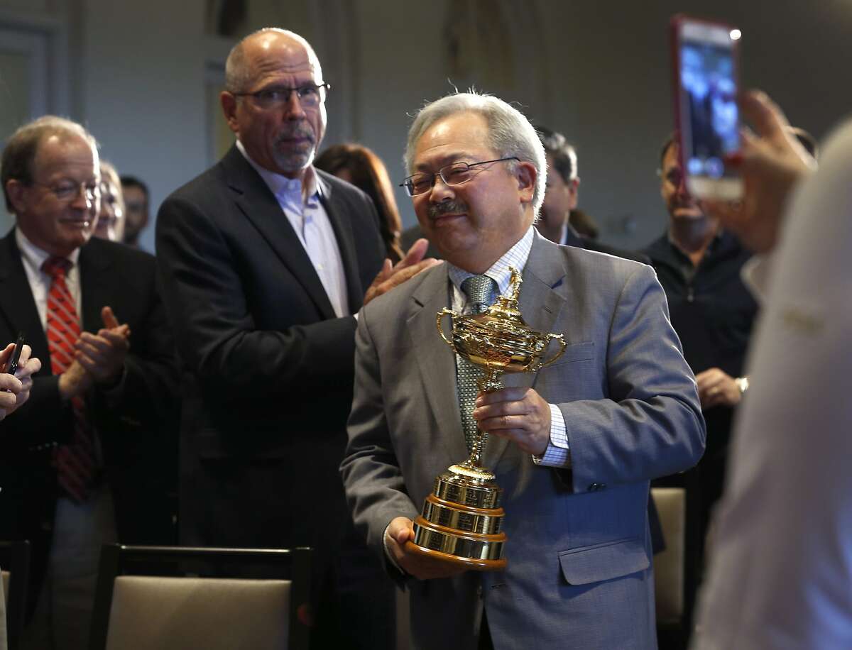 Marry Ed Lee carries the Ryder Cup to the stage after PGA of America officials announce that the Olympic Club will host the 2028 PGA Championship and the Ryder Cup in 2032, in San Francisco, Calif. on Wednesday, Nov. 8, 2017.