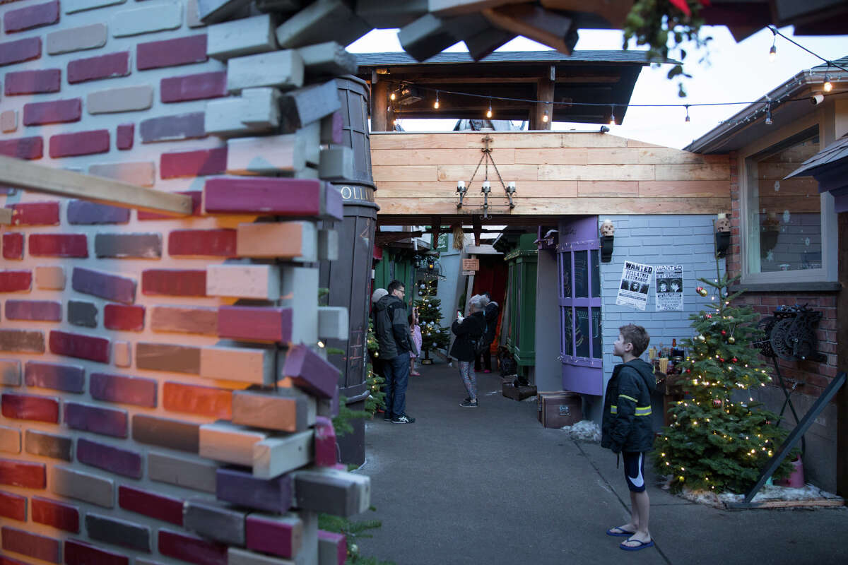 Visitors flock to the now-famed recreation of Diagon Alley, a shopping street location from the Harry Potter books, at a home in Ballard is turned Christmas-themed, seen on Thursday, Dec. 13, 2017.