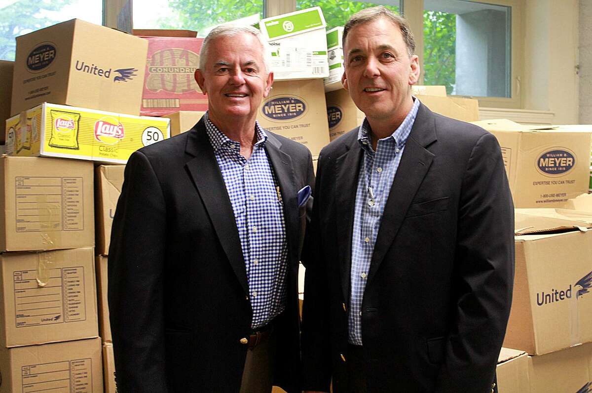 Kevin Kelleher, CEO of Cartus, and Bob Gallucci, vice president of sales for William B. Meyer, pose by the boxes of food that Cartus employees collected to benefit Move for Hunger.
