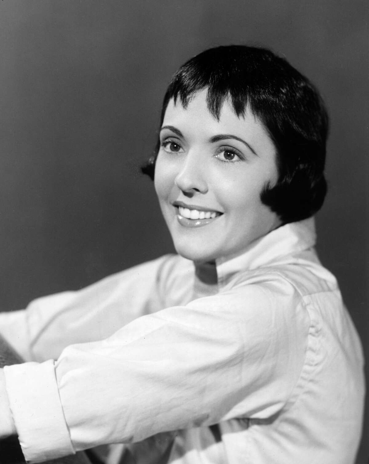 circa 1955: Studio headshot portrait of American singer Keely Smith smiling in an oxford shirt.