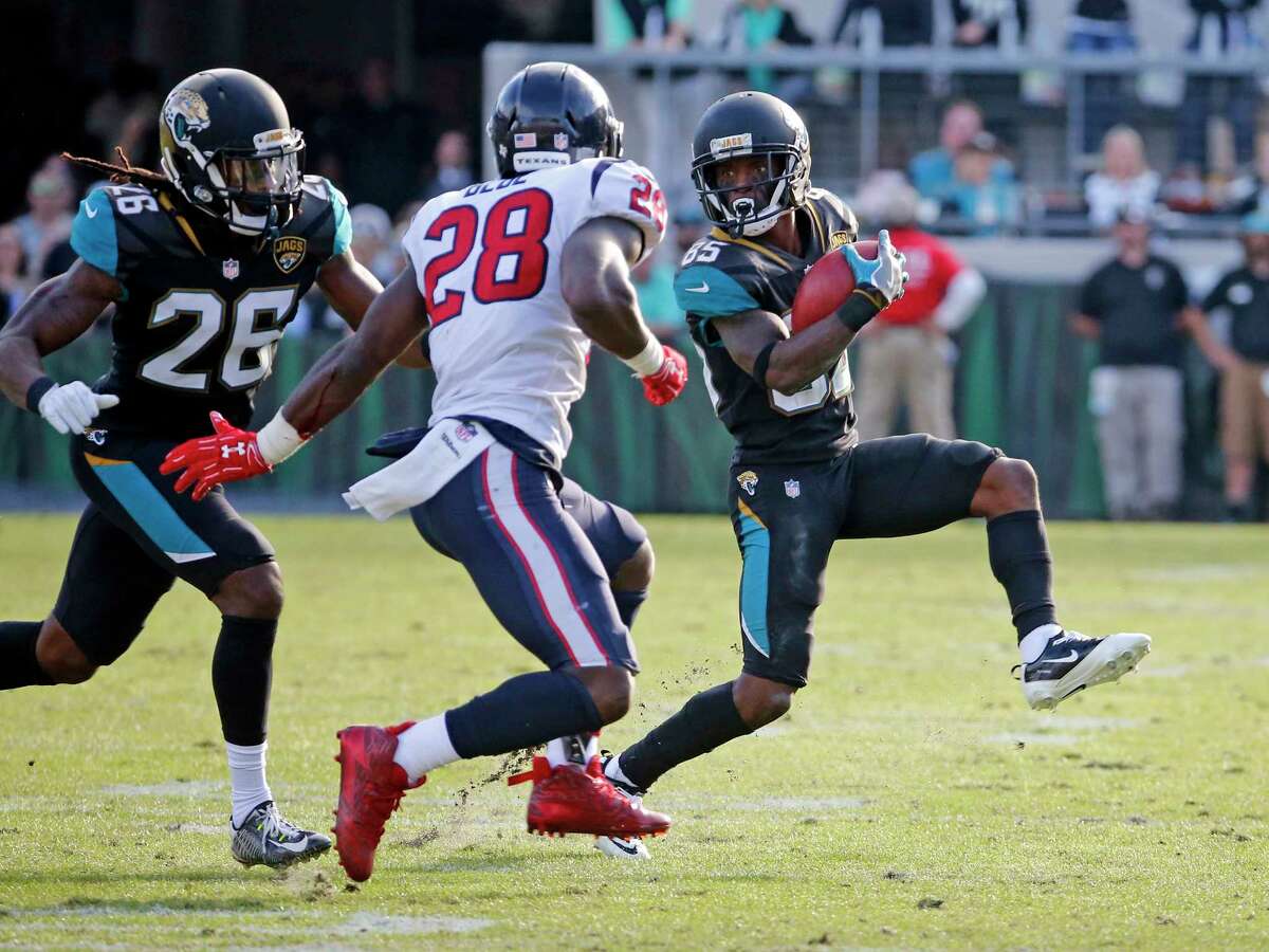 Jacksonville Jaguars' Jaydon Mickens (85) tries to get around Houston Texans' Alfred Blue (28) as Jaguars Jarrod Wilson (26) comes in to black on a punt return during the second half of an NFL football game, Sunday, Dec. 17, 2017, in Jacksonville, Fla. (AP Photo/Stephen B. Morton)