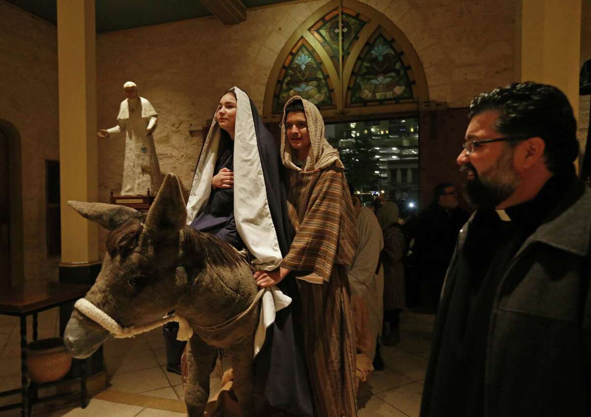 Angela Perez, 15, as Mary, (from left) Alessandro Santos, 14, as Joseph, and others are allowed in to San Fernando Cathedral by Father Victor Valdez (right) during the annual La Gran Posada held Sunday, Dec. 17, 2017. La Gran Posada which is organized by San Fernando Cathedral, tells the story of Mary and Joseph's journey to find a place to stay and for Jesus to be born, began at Milam Park and made its way through downtown with stops in Market Square, the Spanish Governor's Palace, City Hall, the Bexar County Courthouse and ended at San Fernando Cathedral, where Mary and Joseph were allowed in.