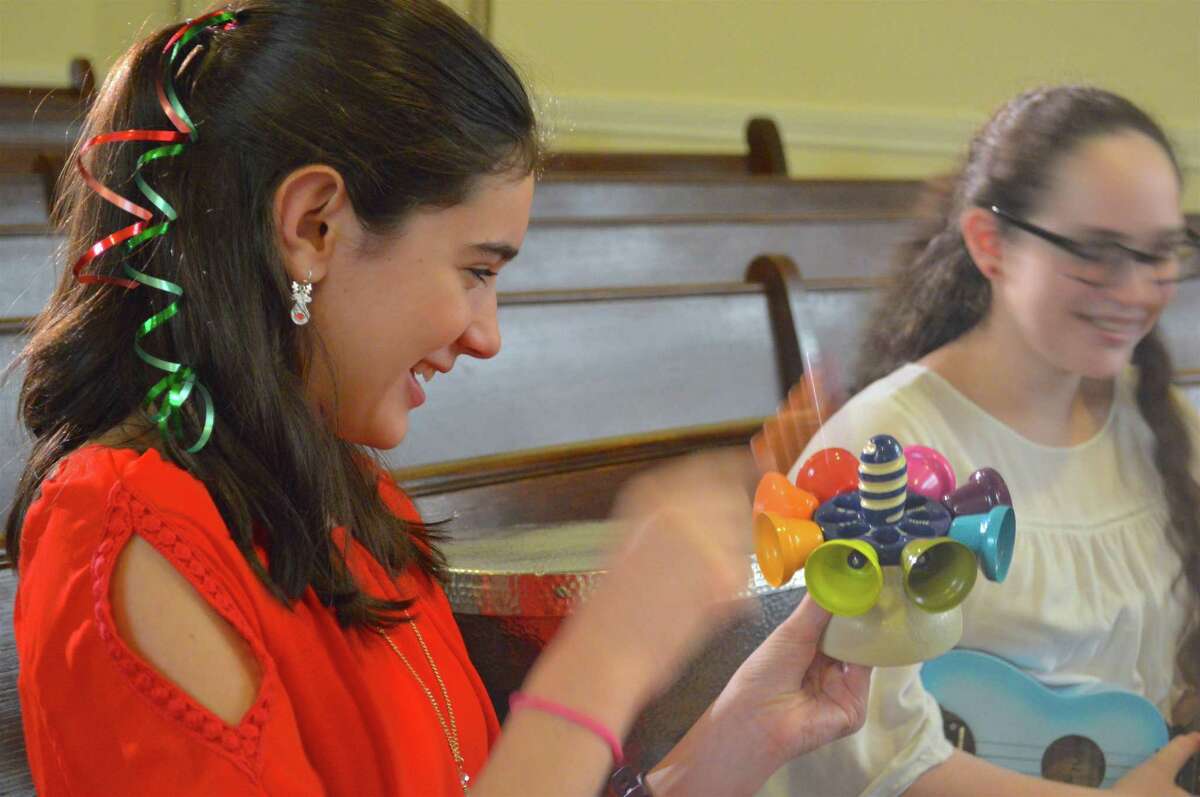 Allison Eidt, 12, of Wilton, tries out a unique kind of instrument at the Free Family Concert at the Seabury Center, sponsored by the Westport Historical Society and Mary Ann Hall's Music for Children and Beyond, Sunday, Dec. 17, 2017, in Westport, Conn.