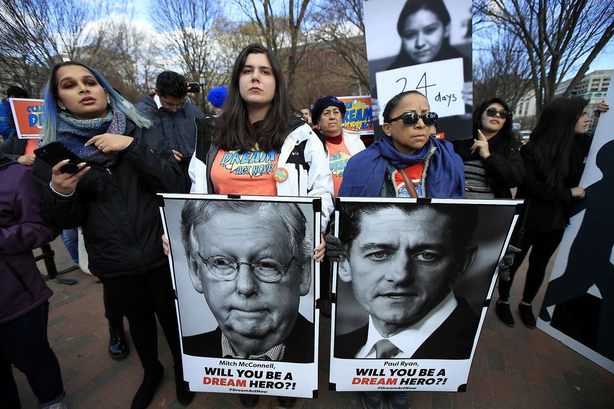 Amanda Bayer, left holding banner, and Marisol Maqueda, right with banner, from Mexico whose daughter Maria Torres also from Mexico City is a DACA recipient finishing her masters degree in Arizona, join a rally outside the White House in Washington, Thursday, Dec. 7, 2017. (AP Photo/Manuel Balce Ceneta).