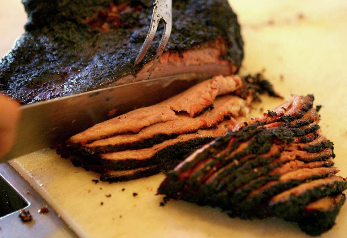 Slices of brisket come off the cutting line.