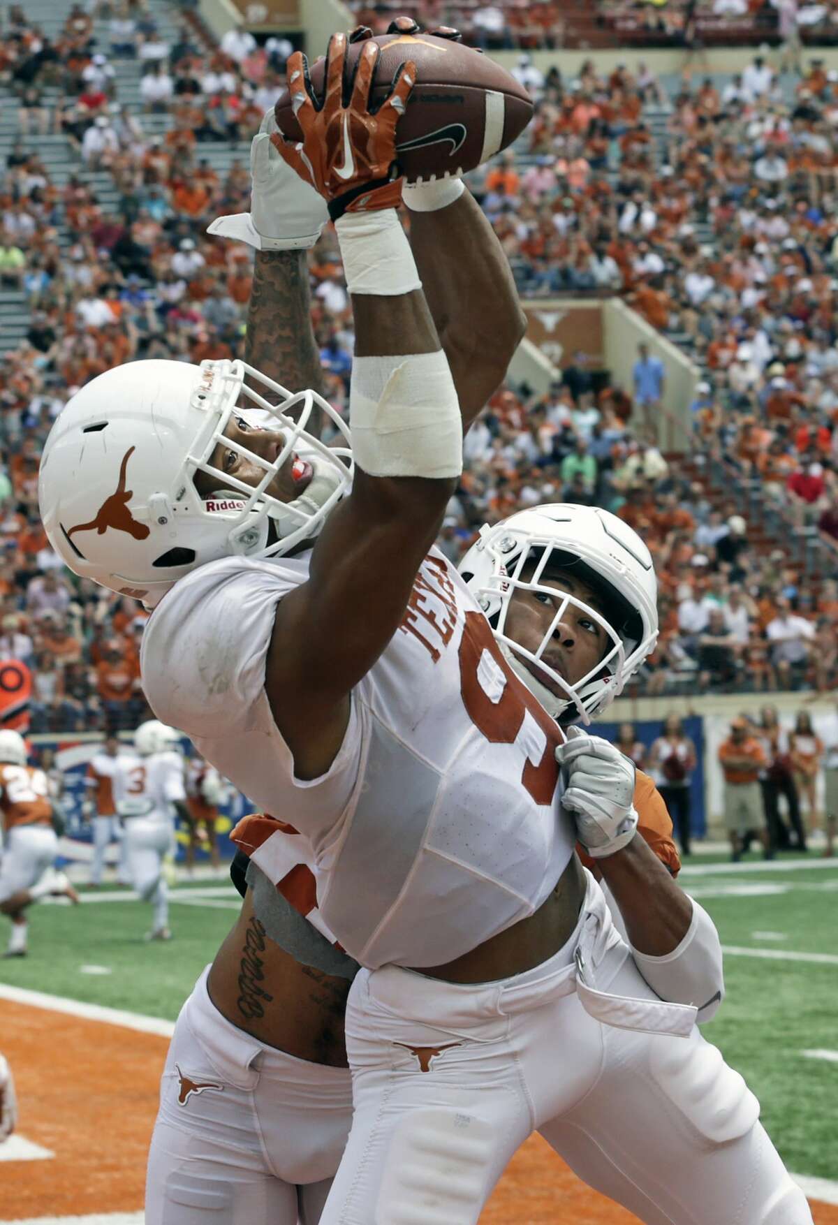 Collin Johnson snares a touchdown pass thrown by Shane Buechele over the defense of Eric Cuffee as the Texas Longhorns play their Orange-White spring game on April 15, 2017.