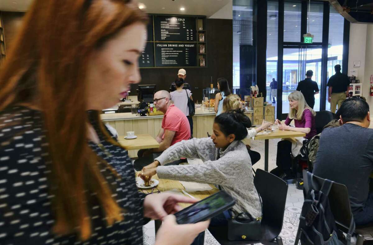 In this Wednesday, Nov. 22, 2017, file photo, customers sit and have their morning coffee and pastries at the LaVazza Cafe, at Eataly, at the Westfield Century City Mall in the Century City section of Los Angeles. Many mall owners are spending billions to add more upscale restaurants and bars, premium movie theaters, bowling alleys and similar amenities.