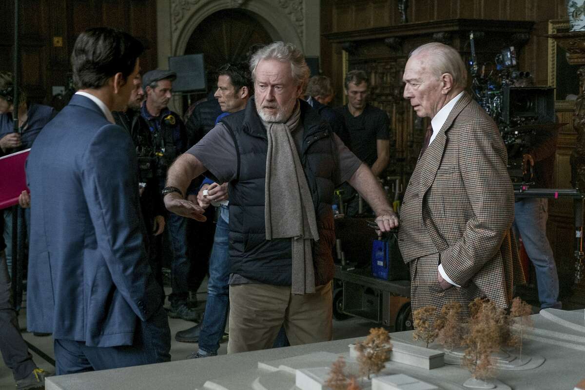 This image released by Sony Pictures shows actors Mark Wahlberg, left, and Christopher Director, right, listening to director Ridley Scott on the set of TriStar Pictures' "All The Money In The World." Scott says he hasn't heard from Kevin Spacey since the decision was made to cut the actor from the film. In October, the film was complete, with Spacey cast as the mogul. However, after sexual misconduct allegations were made against the actor, the decision was made to cut Spacey entirely from the movie and replace him with Plummer. (Giles Keyte/Sony Pictures via AP)