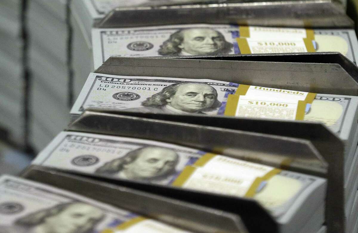 In this Sept. 24, 2013, file photo, freshly-cut stacks of $100 bills make their way down the line at the Bureau of Engraving and Printing Western Currency Facility in Fort Worth, Texas.