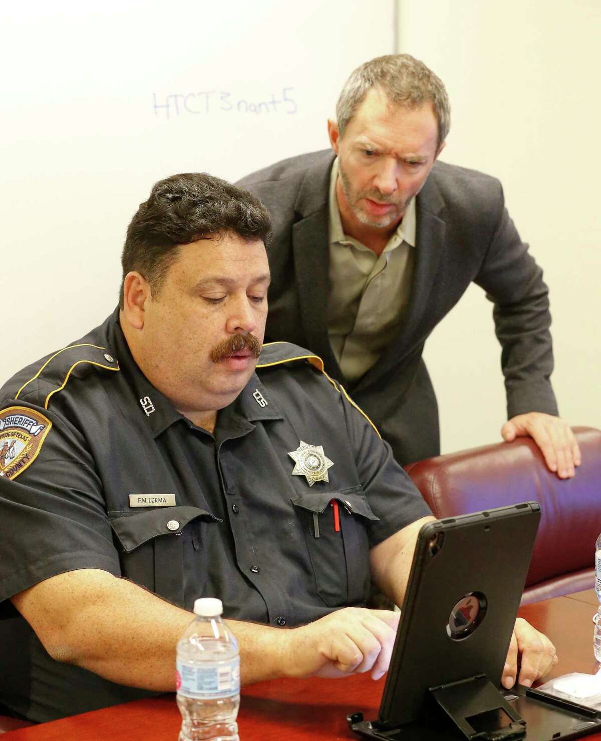 Cloud 9 CEO JC Adams aids Harris County Sheriff Deputy Fred Lerma during a training session of a telepsychiatry program ﻿Dec. 12 in Houston. ﻿Cloud 9 helped make the app a reality.