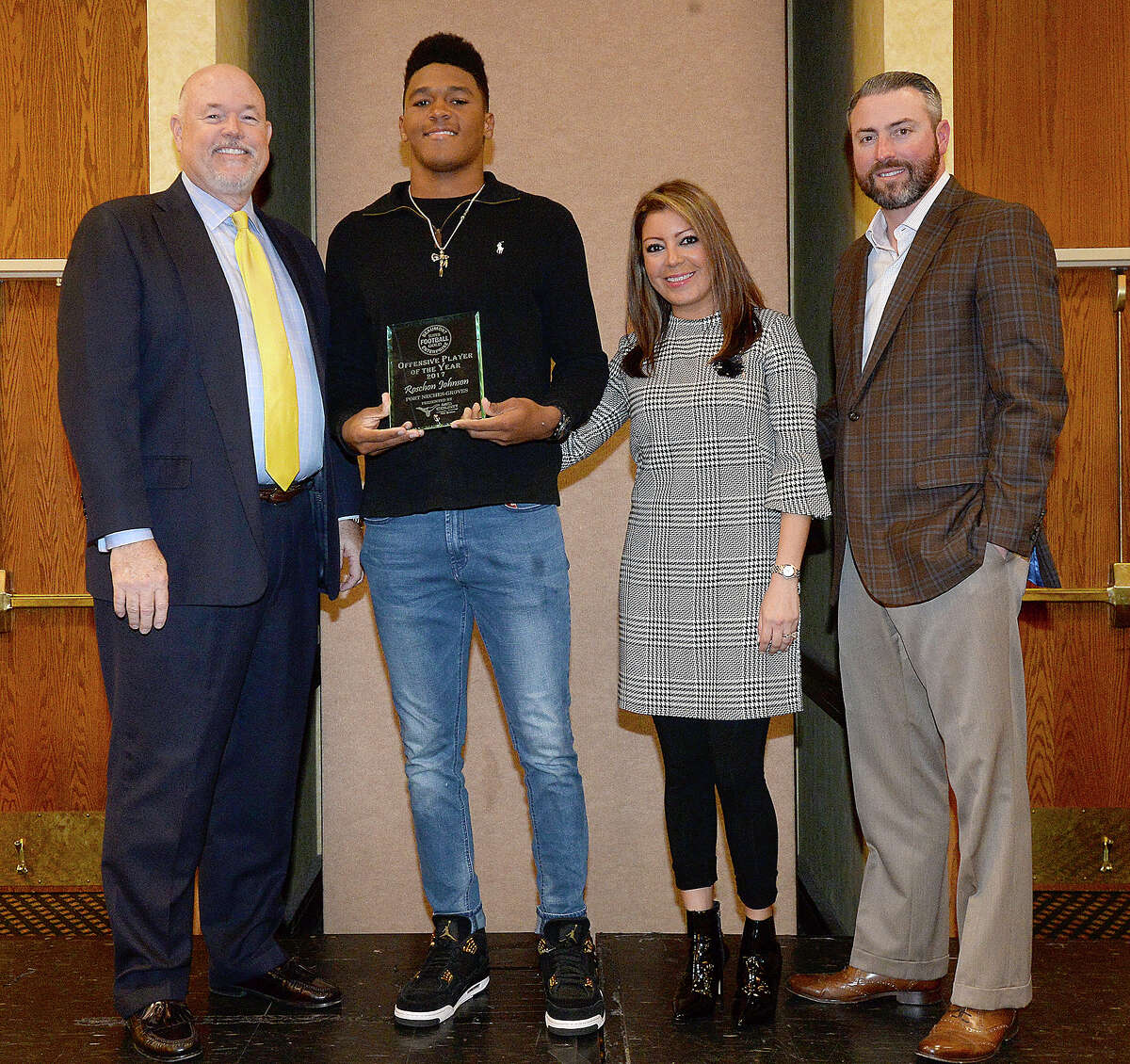 Football offense player of the year Roschon Johnson of Port Neches - Groves receives his placque from Beaumont Enterprise Publisher Mark Adkins and Avi and Allen Tate of sponsor Mid County Chrysler, Dodge, Jeep, Ram, and Fiat, at the Fall Super Gold Awards ceremony Monday at the MCM Elegante Hotel and Conference Center. Photo taken Tuesday, December 11, 2017 Kim Brent/The Enterprise