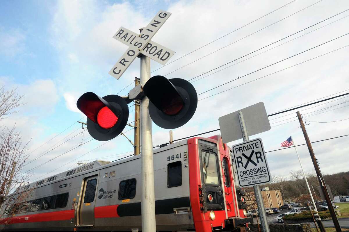 A Grand Central Terminal-bound MetroNorth train crosses an intersection on Largo Drive in the Springdale neighborhood of Stamford, Conn. on Tuesday, Dec. 19, 2017. Gov. Dannel P. Malloy on Wednesday announced that all Connecticut rail lines have been equipped with a safety system called Positive Train Control.