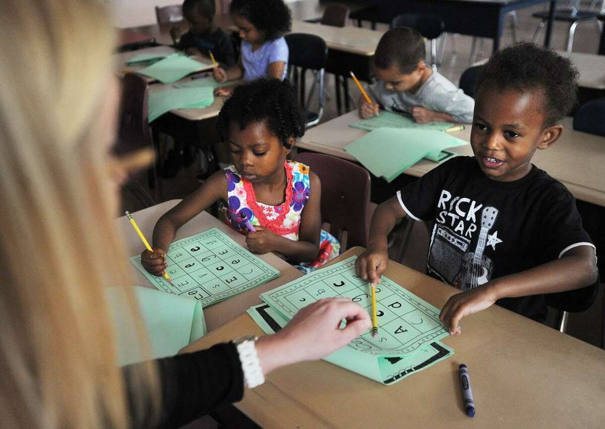 Nazir Mitchell, 4, works on his letters with kindergarten counselor Becky Lengyel during his first day in the Lighthouse summer program at Luis Munoz Marin School in Bridgeport, Conn. on Wednesday, July 5, 2017. The city Board of Education narrowly approved the program, a fixture in city schools since it's founding in 1993.