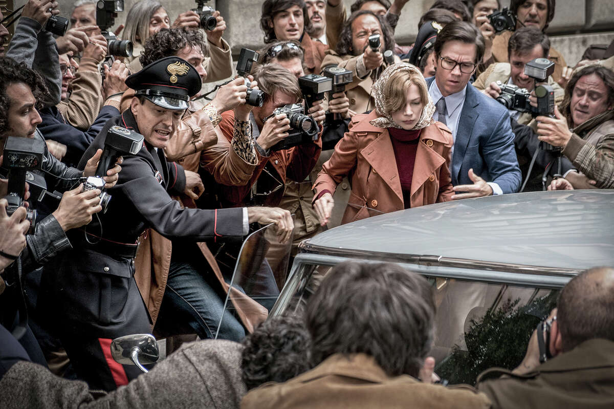Gail Harris (Michelle Williams, in scarf) and Fletcher Chace (Mark Wahlberg, in glasses) are mobbed by paparazzi in "All the Money in the World."